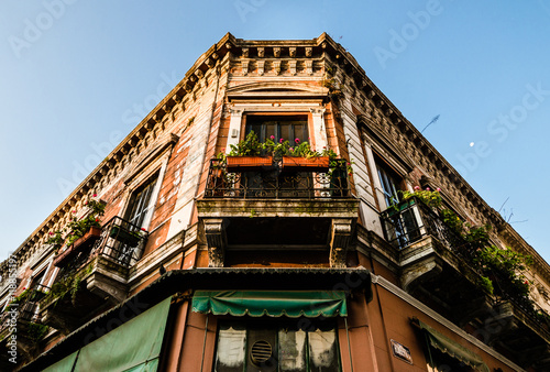 Colorful old and shabby building with beautiful architecture against sunset sky and moon in San Telmo neighborhood, Buenos Aires photo