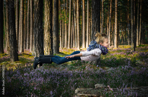 Beautiful blond girl levitates in the forest.