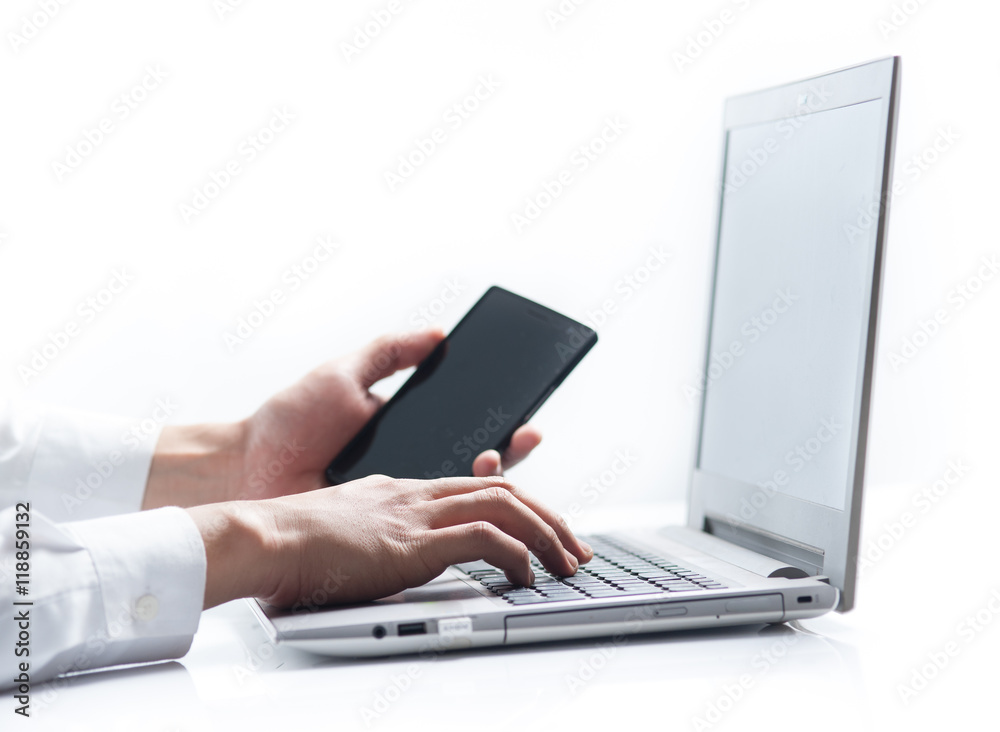 Business man hands busy working on his laptop and using smart phone Business man hands busy working on his laptop and using smart phone