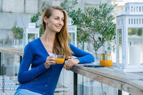 Young pretty woman enjoys cup of tea in outdoor cafe
