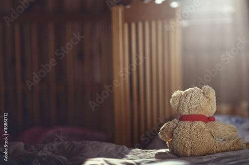Teddy bear in an empty child's room photo