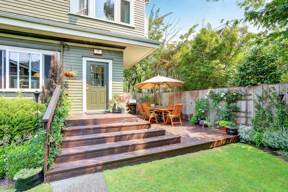Backyard area with walkout deck and well kept lawn. - obrazy, fototapety, plakaty 