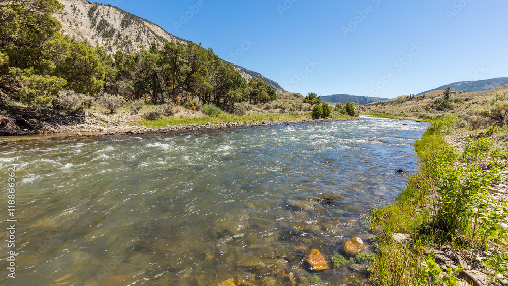The flow of water among the rocks. Beautiful brown stones on the river bottom. Fast flowing river on the background of the rocky coast. Boiling River Trail, Yellowstone National Park, Wyoming
