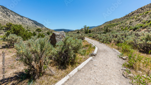 The path among the bushes on a background of mountains. Arid landscape. Boiling River Trail, Yellowstone National Park, Wyoming