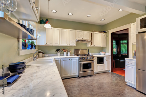 Bright kitchen interior with white cabinets and marble counter top