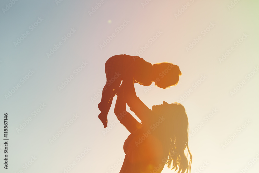 Naklejka premium mother and little daughter play at sunset