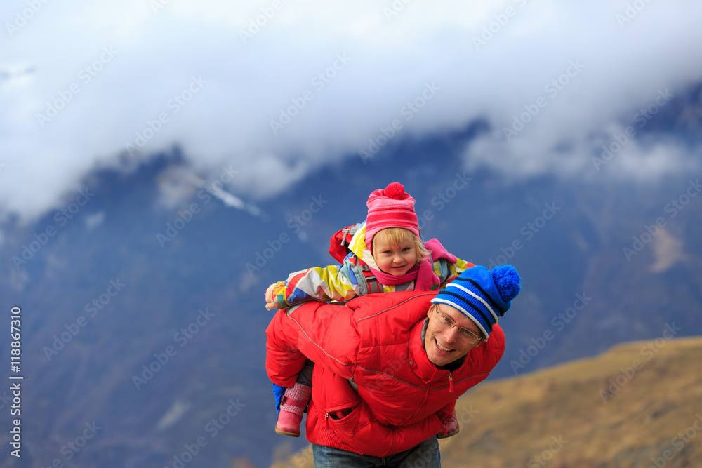 happy father and little daughter travel in winter mountains