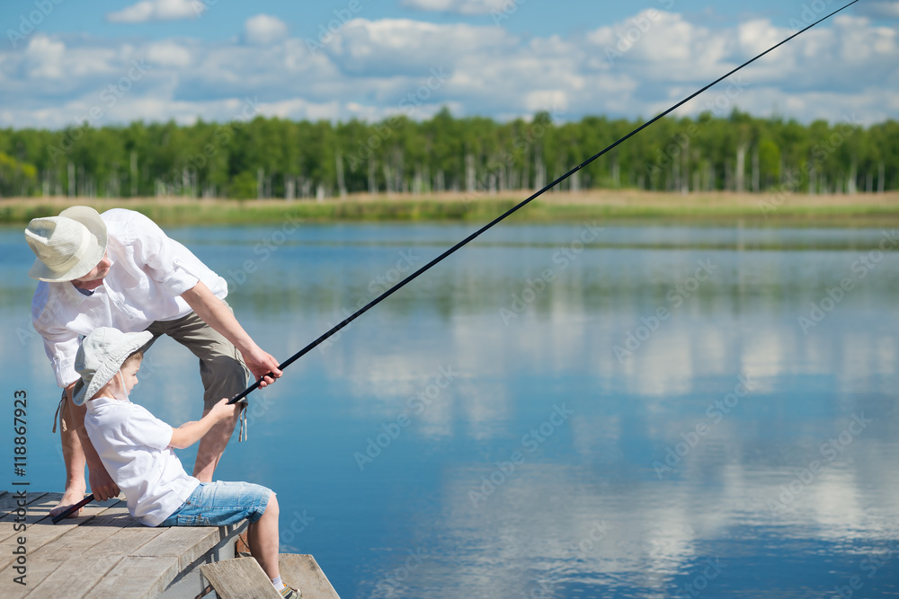 Dad and son caught the fish and pull it Dad and son caught the fish and pull it