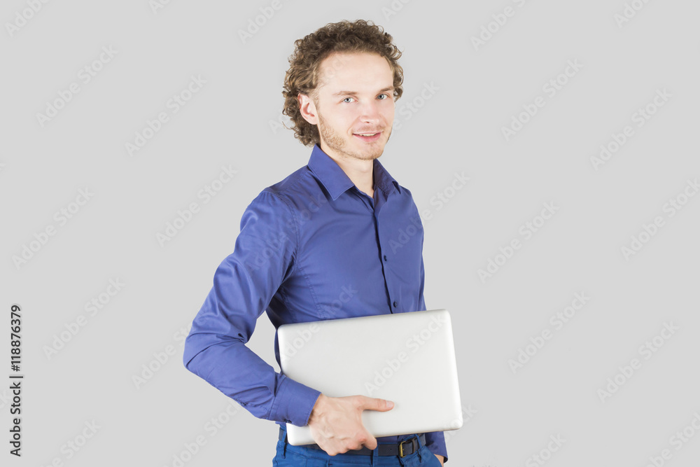 Smiling intelligent man with laptop in hand in studio on gray background. Modern lifestyle. Smiling intelligent man with laptop in hand in studio on gray background. Modern lifestyle.