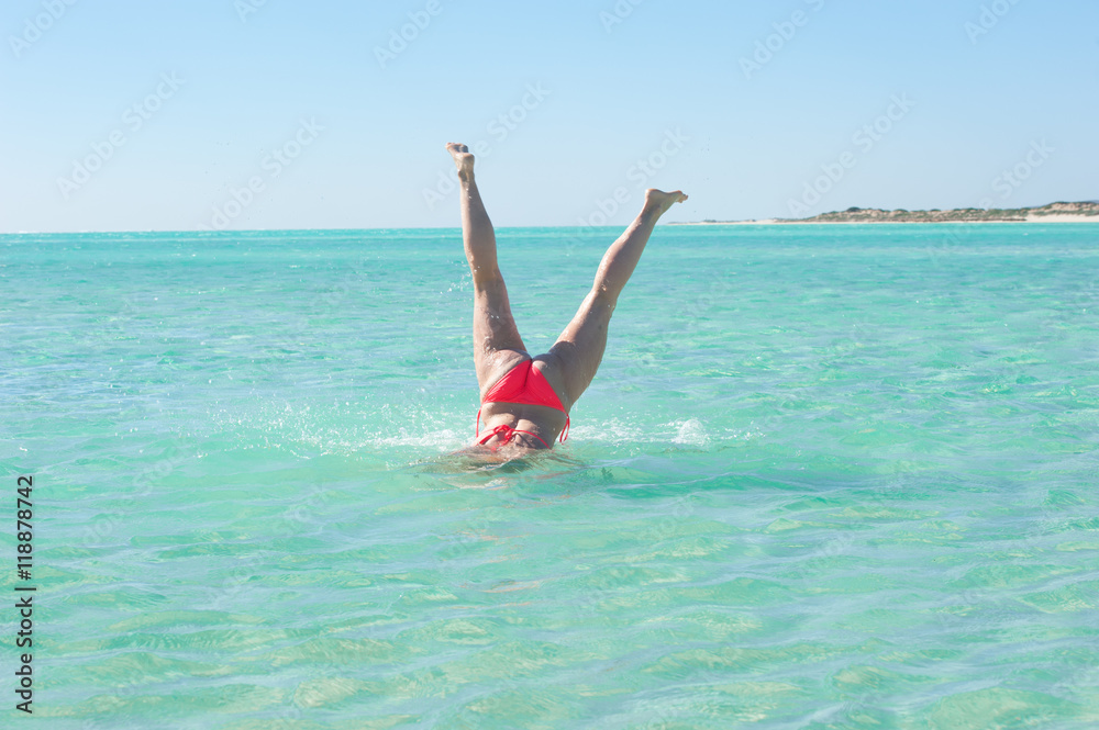 Underwater handstand young woman beach