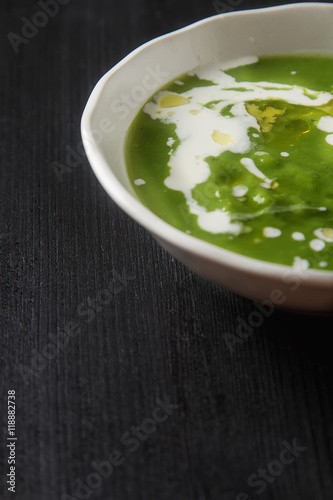 Pea soup puree with cream and olive oil in an old white bowl, pa