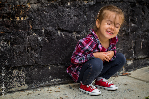 little beautiful girl near brick wall