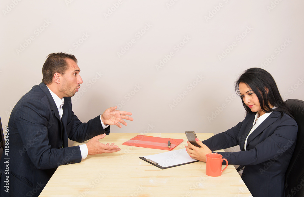 Woman looking at the smartphone and ignoring her companion Woman looking at the smartphone and ignoring her companion