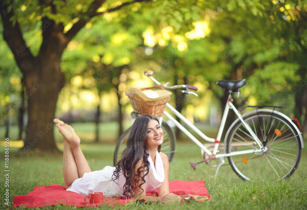 Obraz premium Young beautiful woman reading book outdoors in park on a sunny d