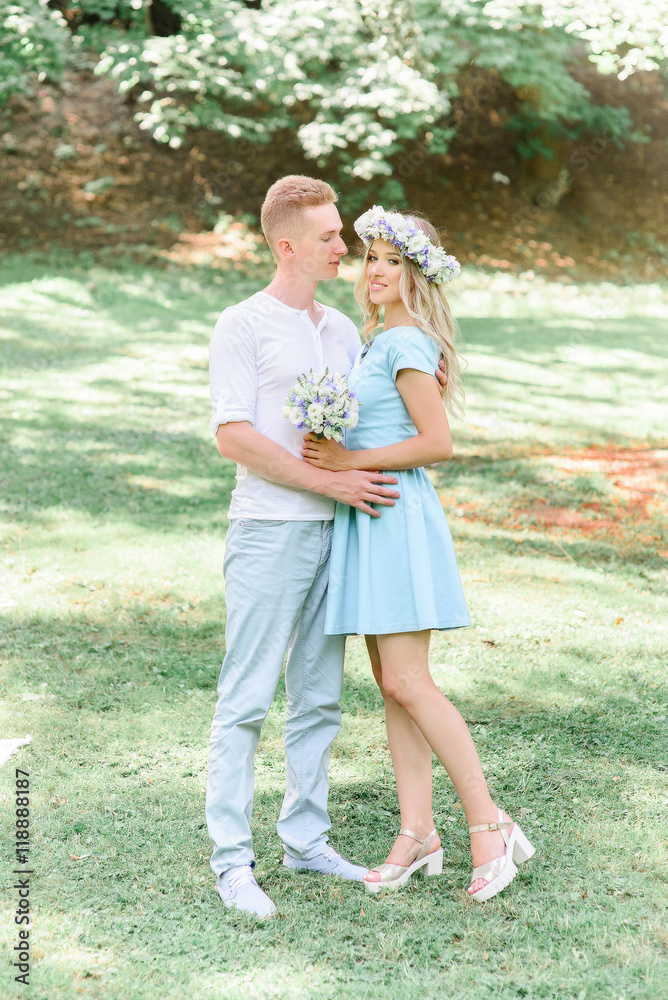 Man holds his hands on the waist of woman in blue dress and whit Man holds his hands on the waist of woman in blue dress and whit