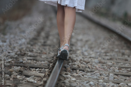 mujer caminando sobre vía de tren