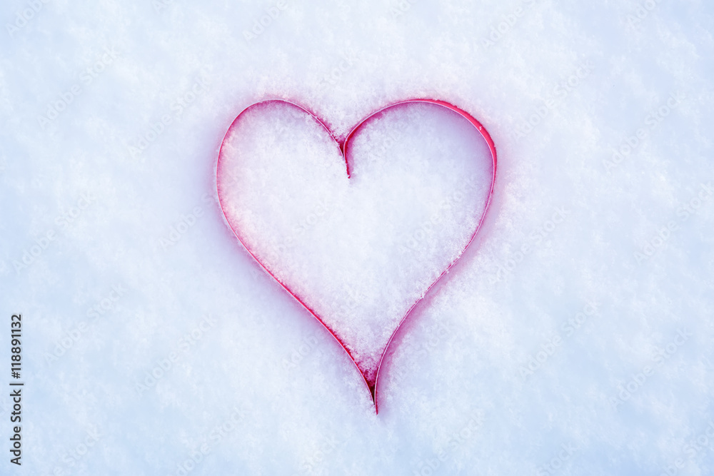 Heart in a snow-covered snowdrift. Concept of Christmas and Valentine's Day