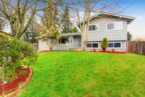 Two story house with garage, driveway and well kept lawn.