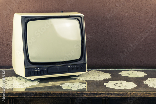 Old retro TV on vintage table, brown background