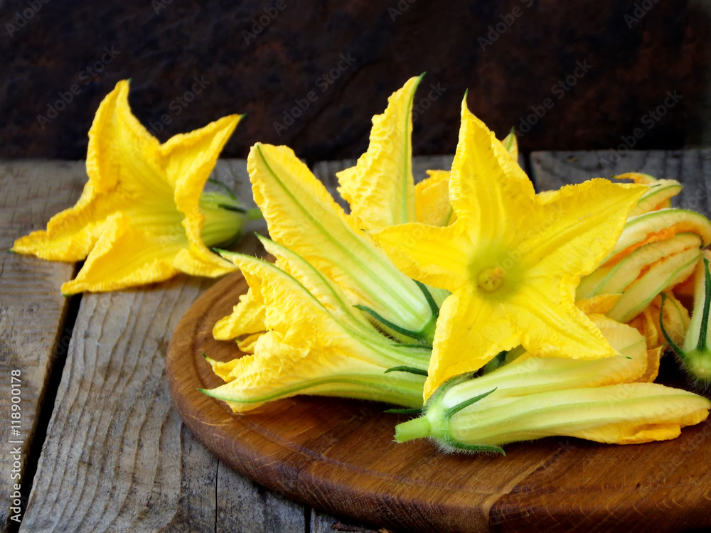 Foto fresh, organic flowers of zucchini on wooden table