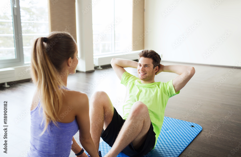 woman with personal trainer doing sit ups in gym woman with personal trainer doing sit ups in gym