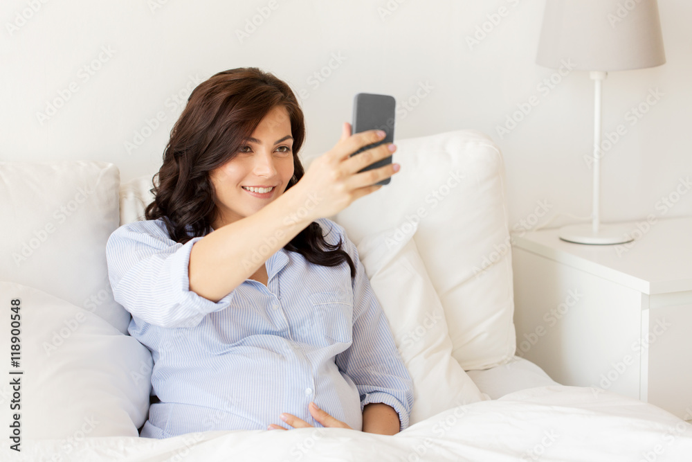 pregnant woman taking smartphone selfie at home pregnant woman taking smartphone selfie at home