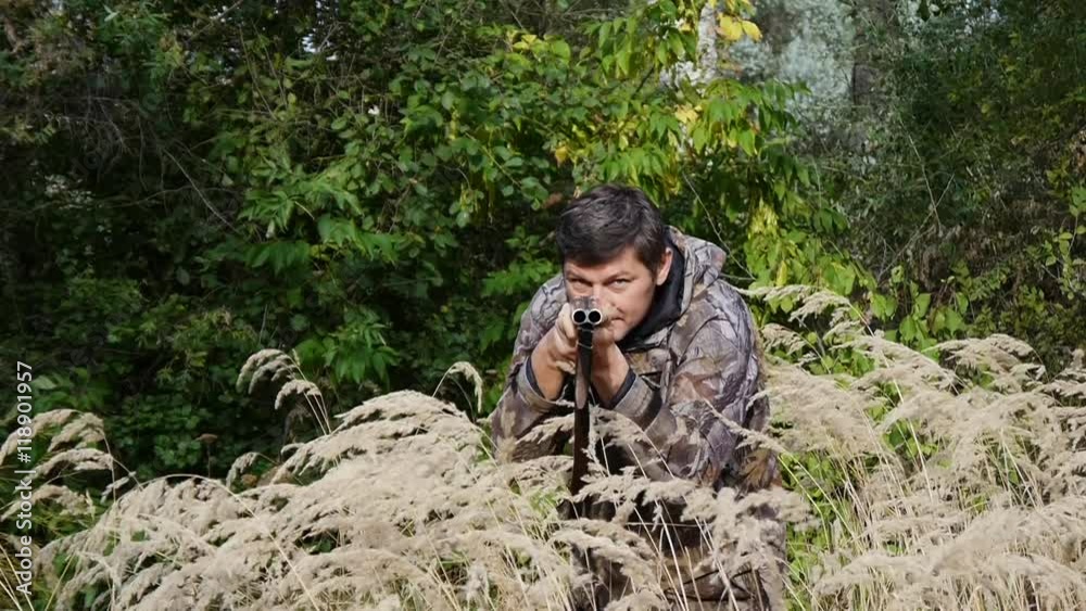 Hunter hiding in the tall grass and wild beast hunts Hunter hiding in the tall grass and wild beast hunts