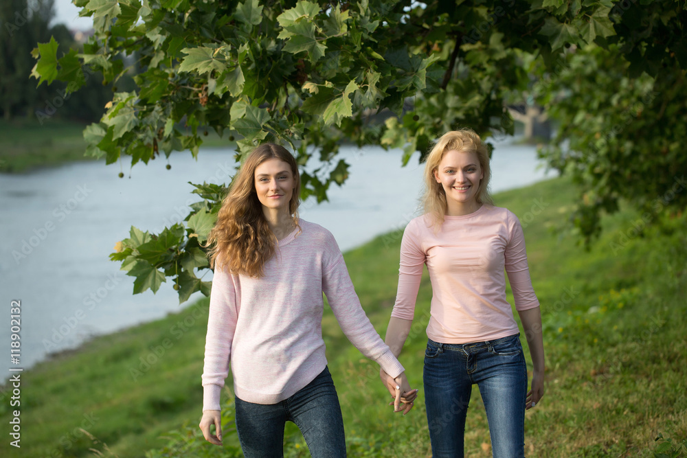 Two young girls hold hands