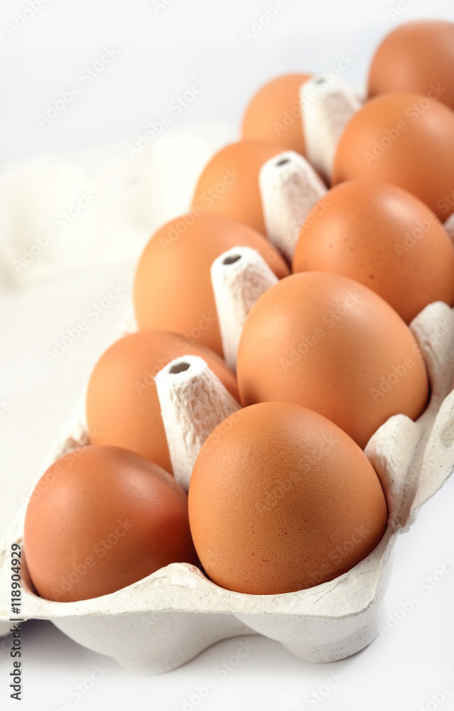Carton of fresh brown eggs on a white Carton of fresh brown eggs on a white