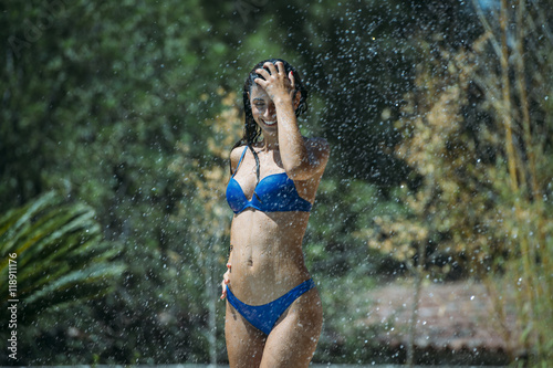 Young woman taking shower in sunlight photo