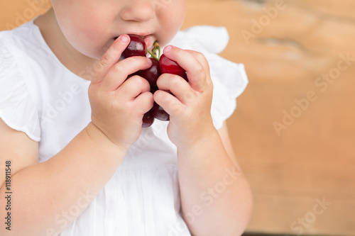 little girl eating cherries