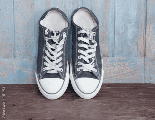 Sport shoes / Dirty sport shoes on wood background. Vintage style.