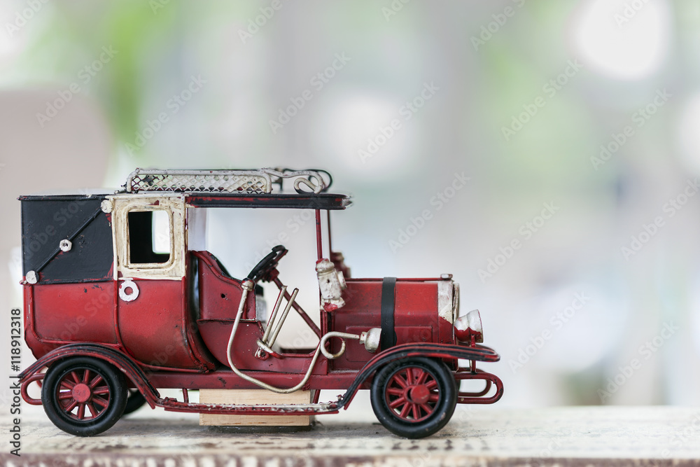 red vintage toy car on wooden table.