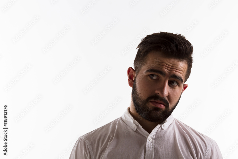 Obraz premium Portrait of thoughtful handsome man looking away while posing isolated on white background in studio. Emotions concept. Hard light concept.