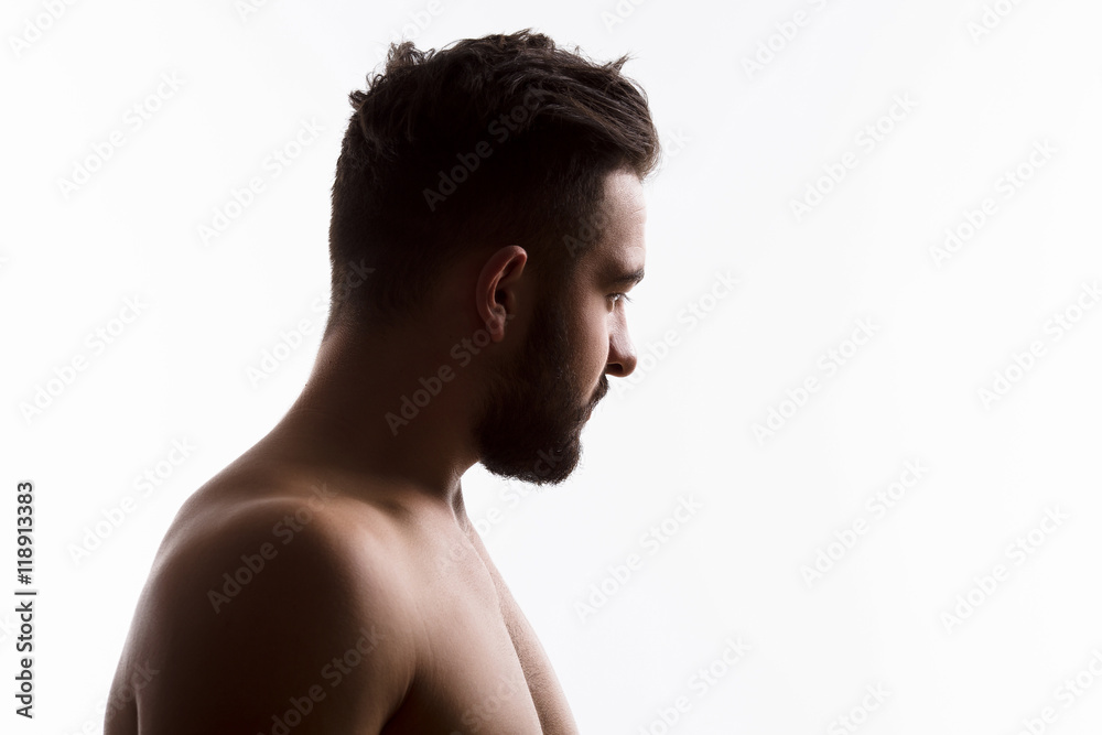Closeup profile of naked handsome hipster man looking away while posing isolated on white background in studio. Emotions concept.