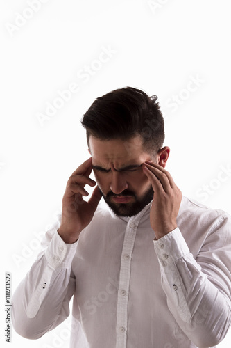 Portrait of thoughtful handsome hipster man posing in studio. Young man in white shirt touching his head isolated on white background.