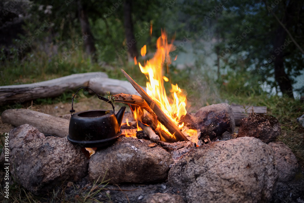 Campfire and the old kettle in twilight Campfire and the old kettle in twilight
