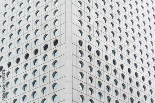Pattern of gray building with circular glass windows.