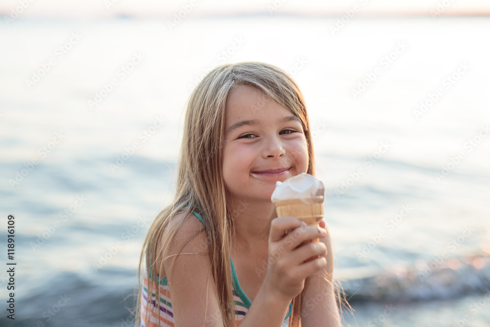 Beautiful little girl eats ice-cream in the summer Beautiful little girl eats ice-cream in the summer