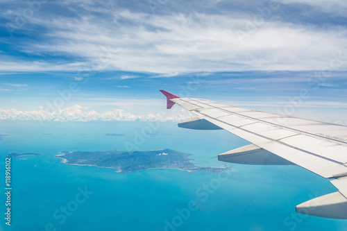 Wing of a plane from window view with Koh Samui in background in Surat Thani, Thailand.