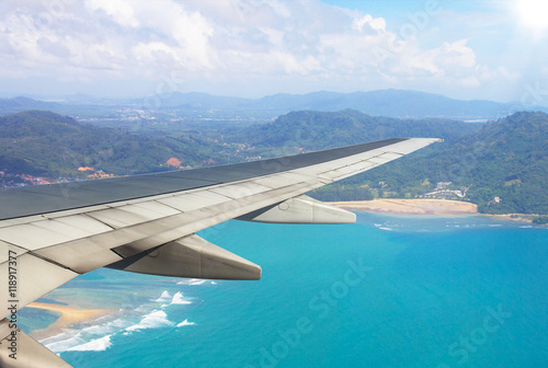 Airplane flying above beach sea blue in phuket island - Travel Concept