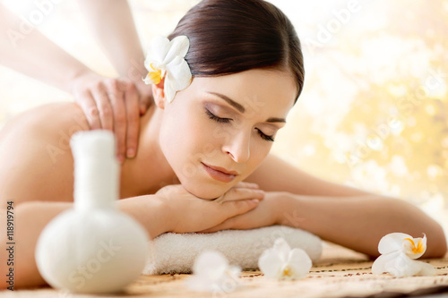Beautiful young woman on a back massage procedure