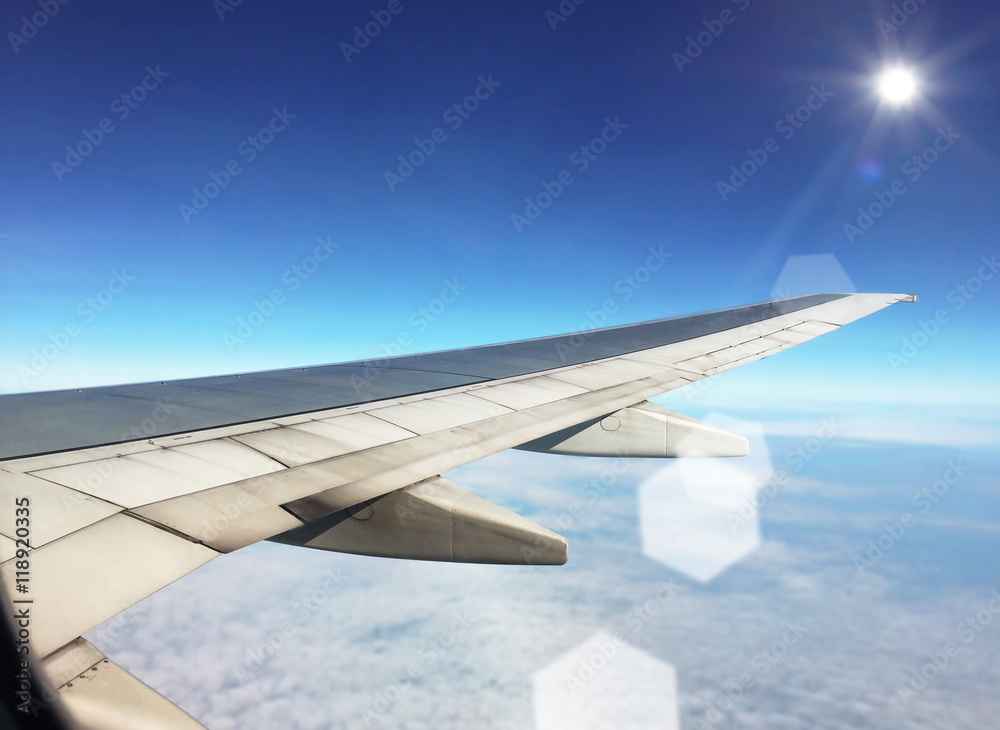 Airplane wing fly above clouds with bright sunlight Airplane wing fly above clouds with bright sunlight