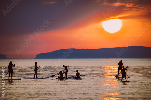 SUP im Sonnenuntergang/Gruppe von SUP`s in der Sonne