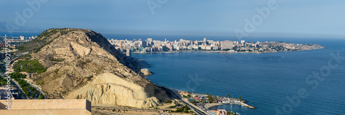 Panoramic view on Alicante harbor with high mountain and spit going to the sea, Spain