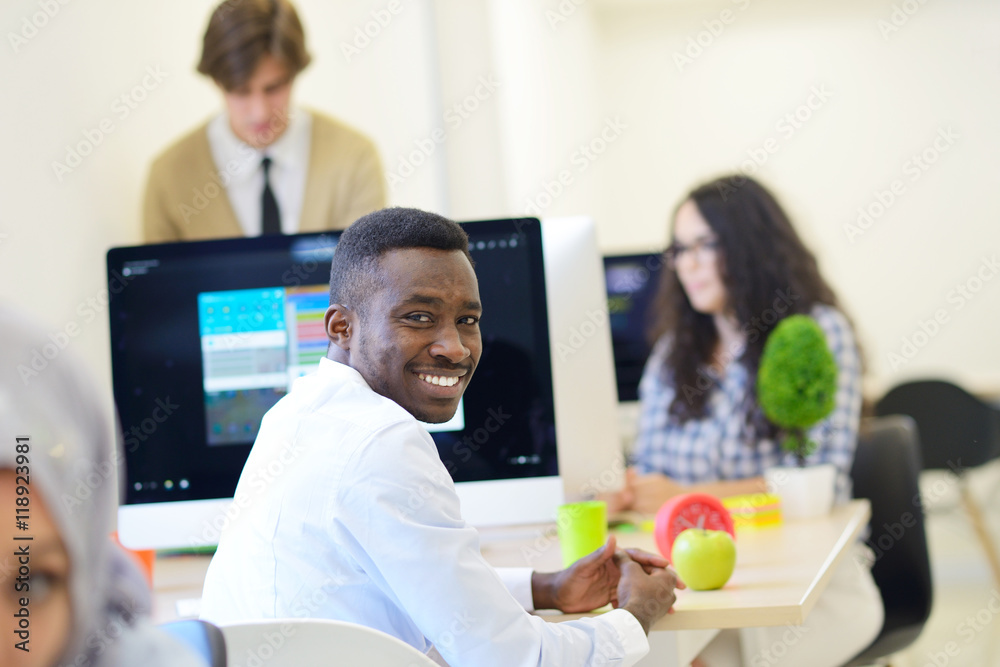 Group of entrepreneurs working using a laptop and holding a document Group of entrepreneurs working using a laptop and holding a document