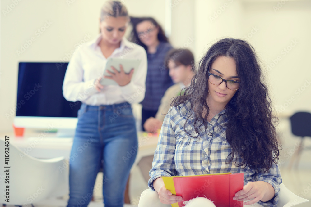 Charming girl holding a folder and looking at camera with a smile at modern startup office Charming girl holding a folder and looking at camera with a smile at modern startup office