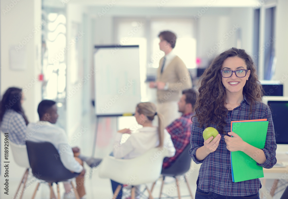 business, startup and people concept - happy creative team with computer and folder in office