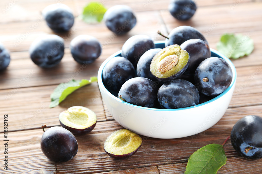Tasty and ripe plums on brown wooden table Tasty and ripe plums on brown wooden table