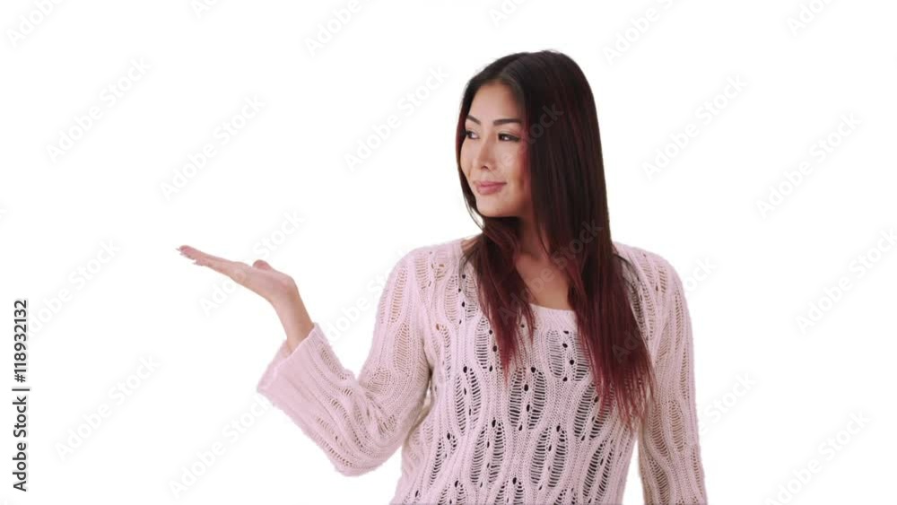 Asian woman standing in front of white screen with hand out Asian woman standing in front of white screen with hand out